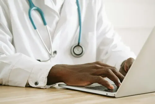 image of doctor writing on his laptop.